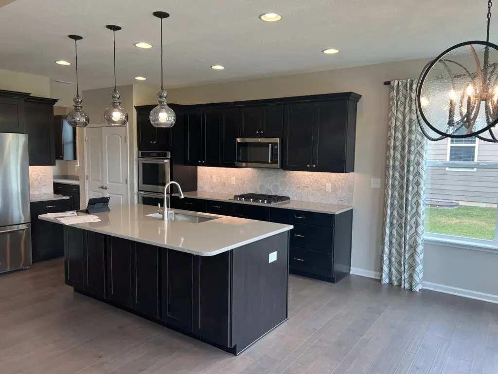 Kitchen with painted dark cabinets and white island