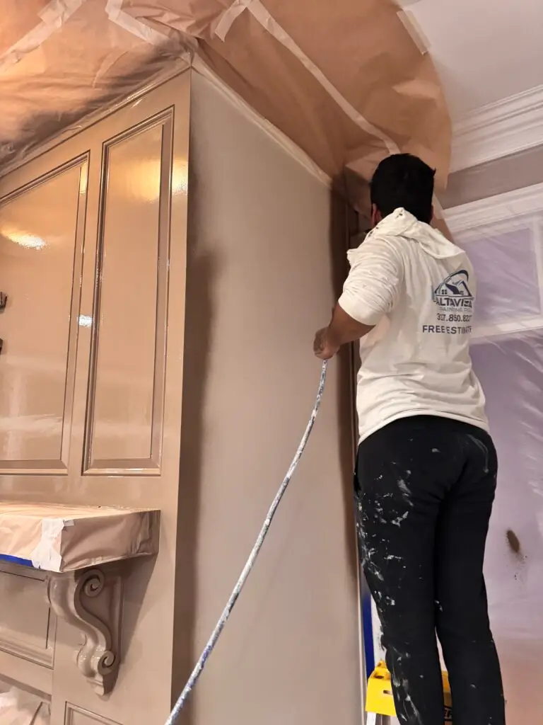 Painter Spraying cabinets in carmel