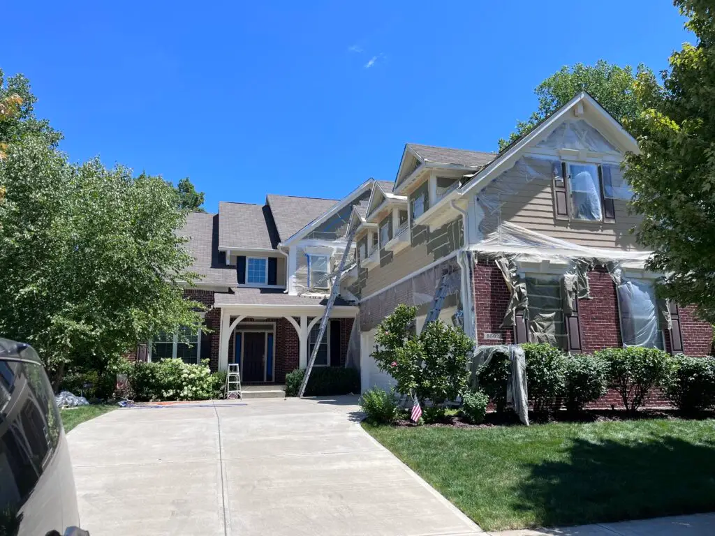 Two-story home fully masked and prepped before exterior painting