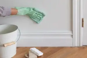 Cleaning a wall with a sponge as part of how to prep walls for painting