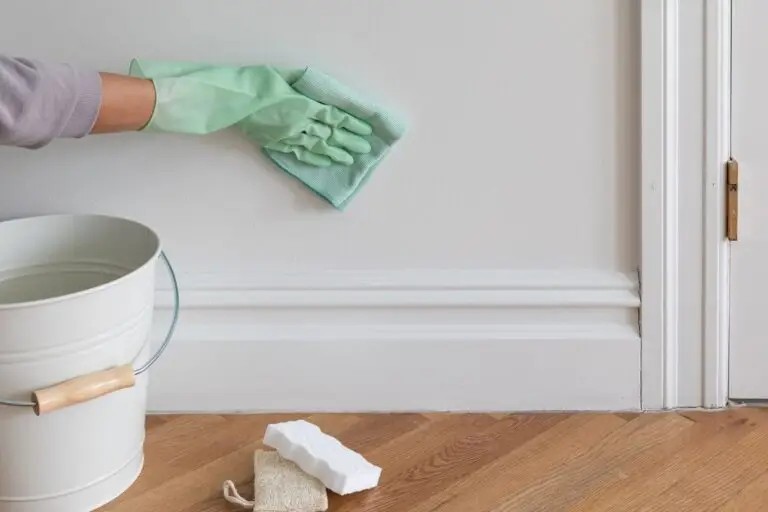Cleaning a wall with a sponge as part of how to prep walls for painting