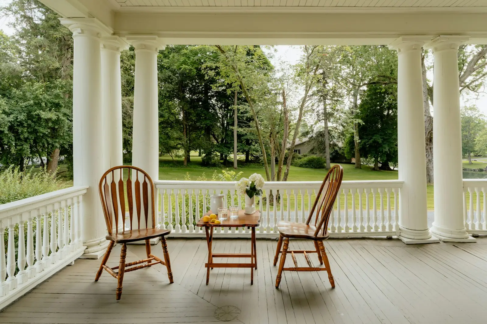 Covered front porch with freshly painted white railings and columns