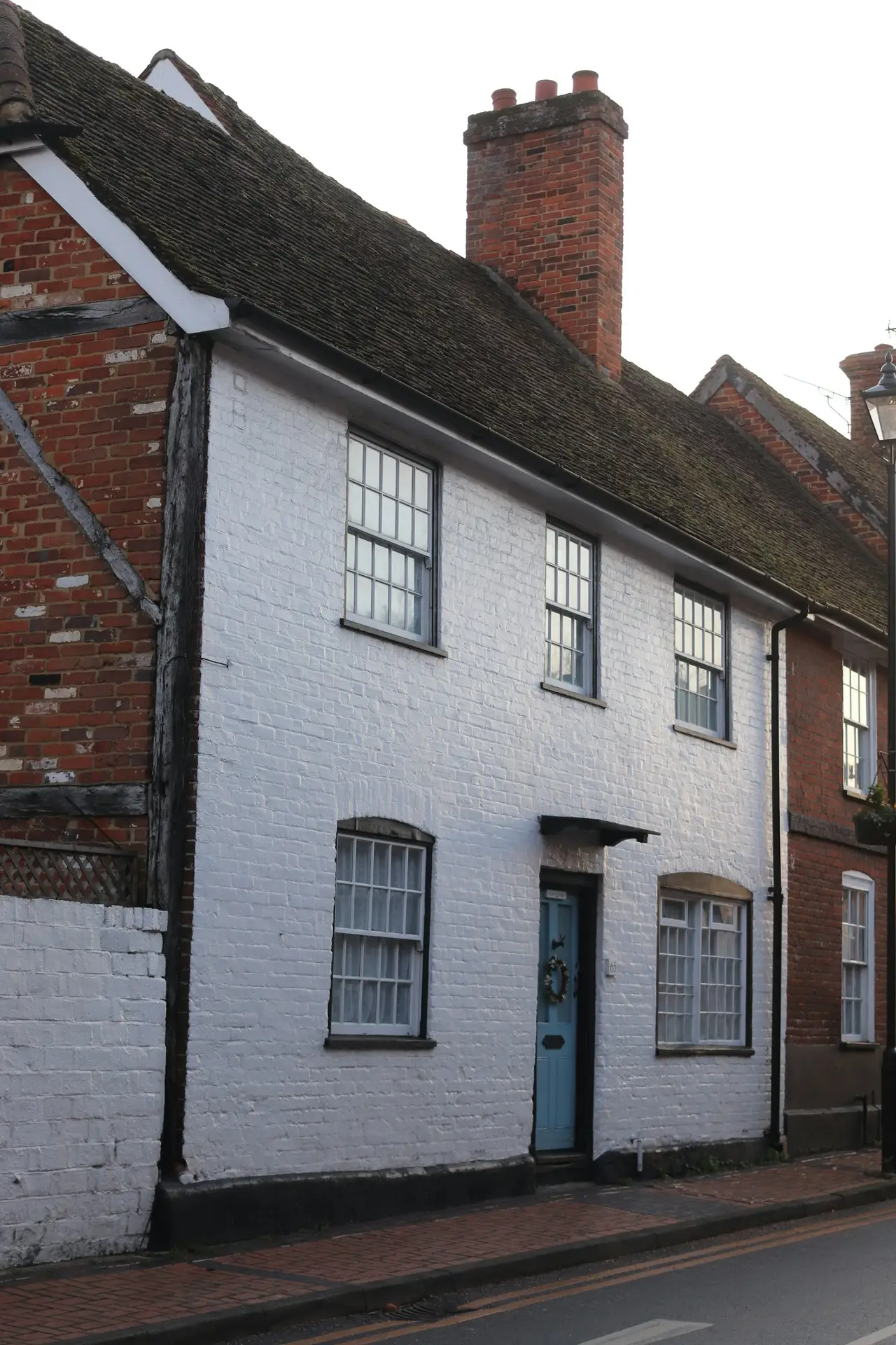 Street of white limewashed brick homes — aged European limewash character