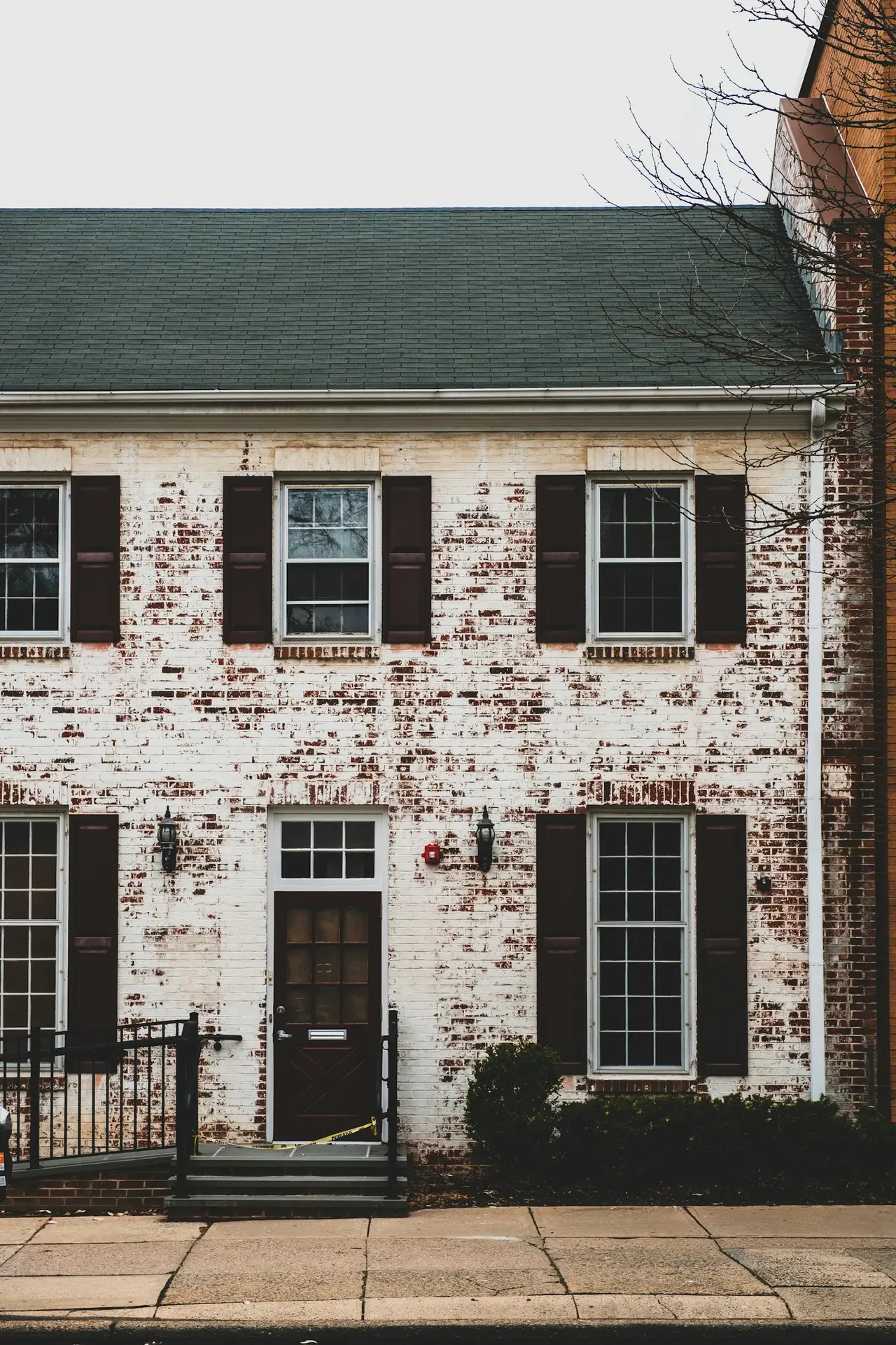 Brick home with a distressed white limewash finish showing hints of original brick — the classic limewash painting look