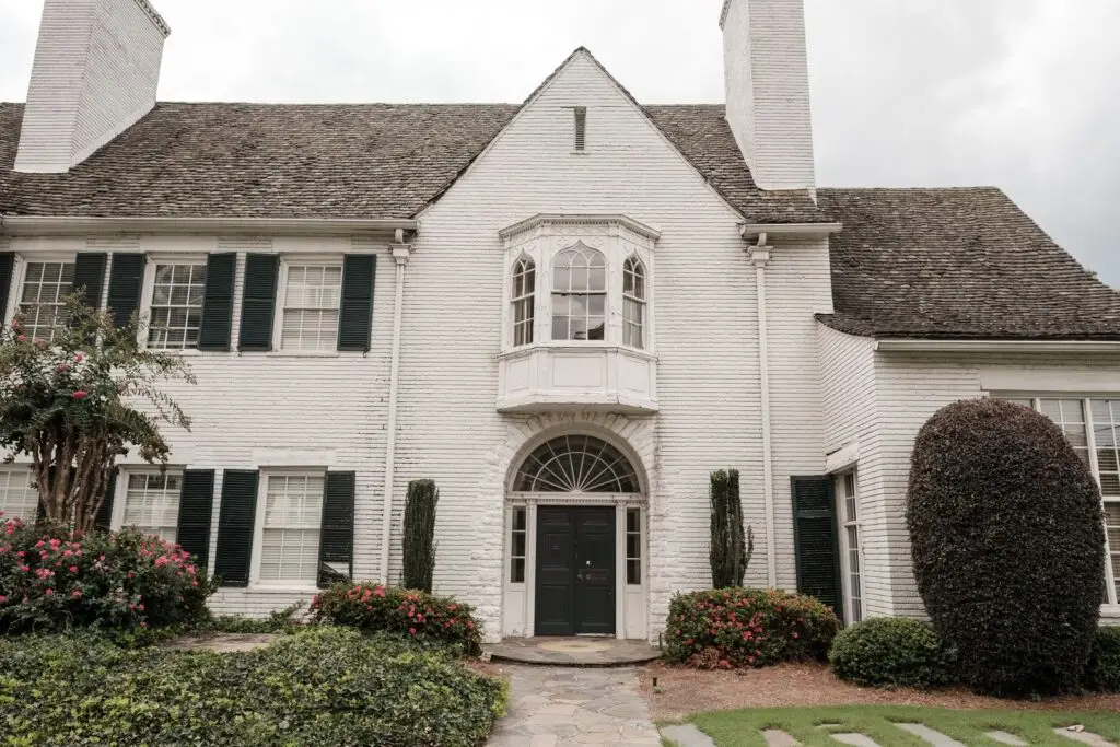 White limewashed brick home with black shutters