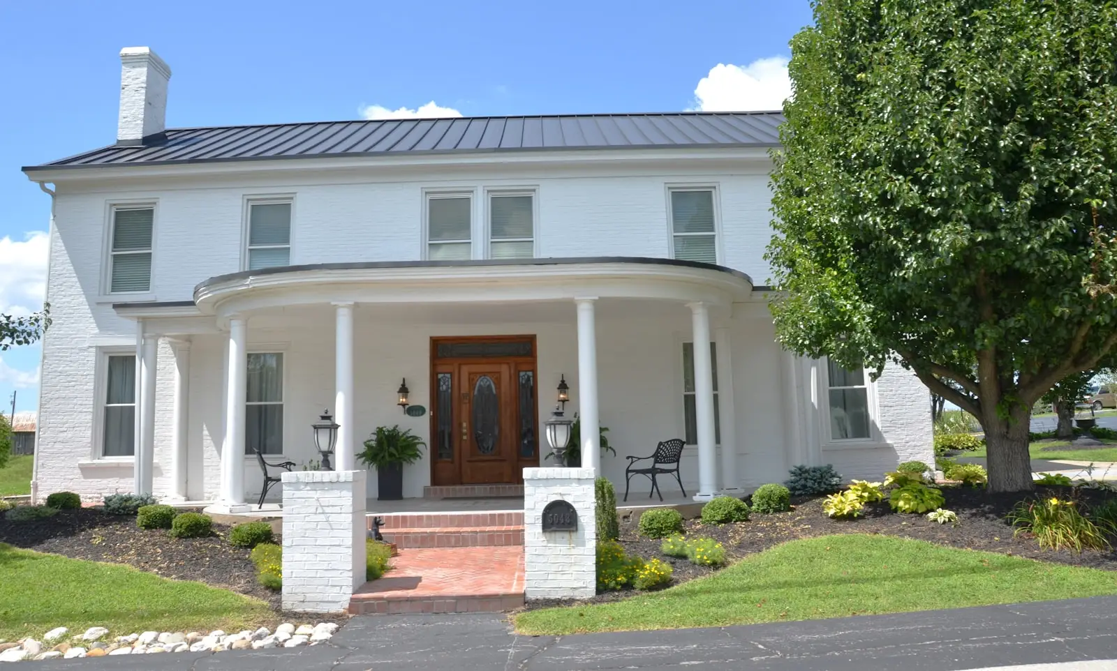 White brick colonial home exterior with covered porch — full-coverage mineral paint finish