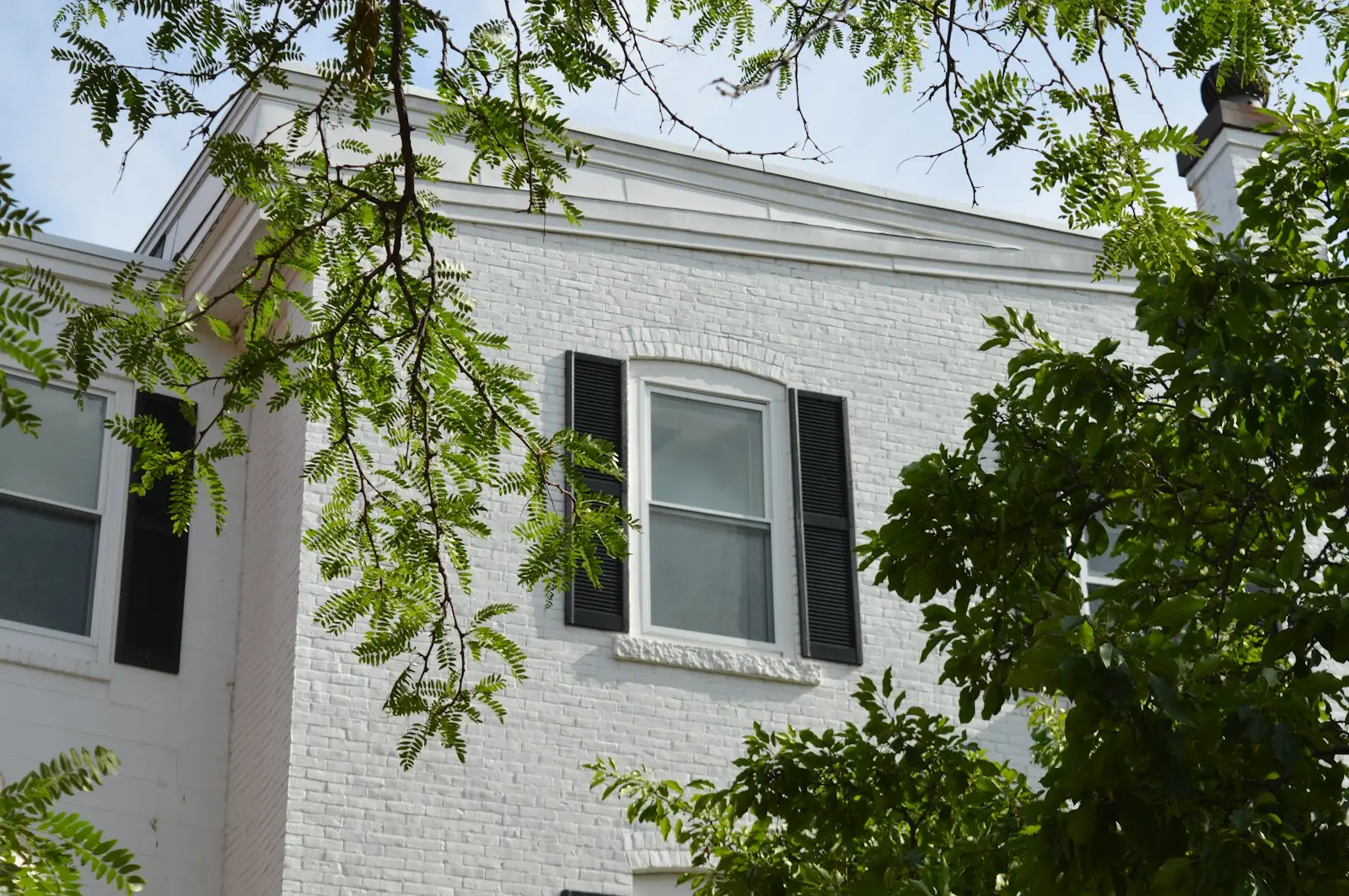 White brick house exterior with black shutters — timeless limewashed brick curb appeal